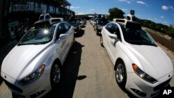 In this Monday, Sept. 12, 2016, photo, a group of self-driving Uber vehicles position themselves to take journalists on rides during a media preview at Uber's Advanced Technologies Center in Pittsburgh. (AP Photo/Gene J. Puskar, File)