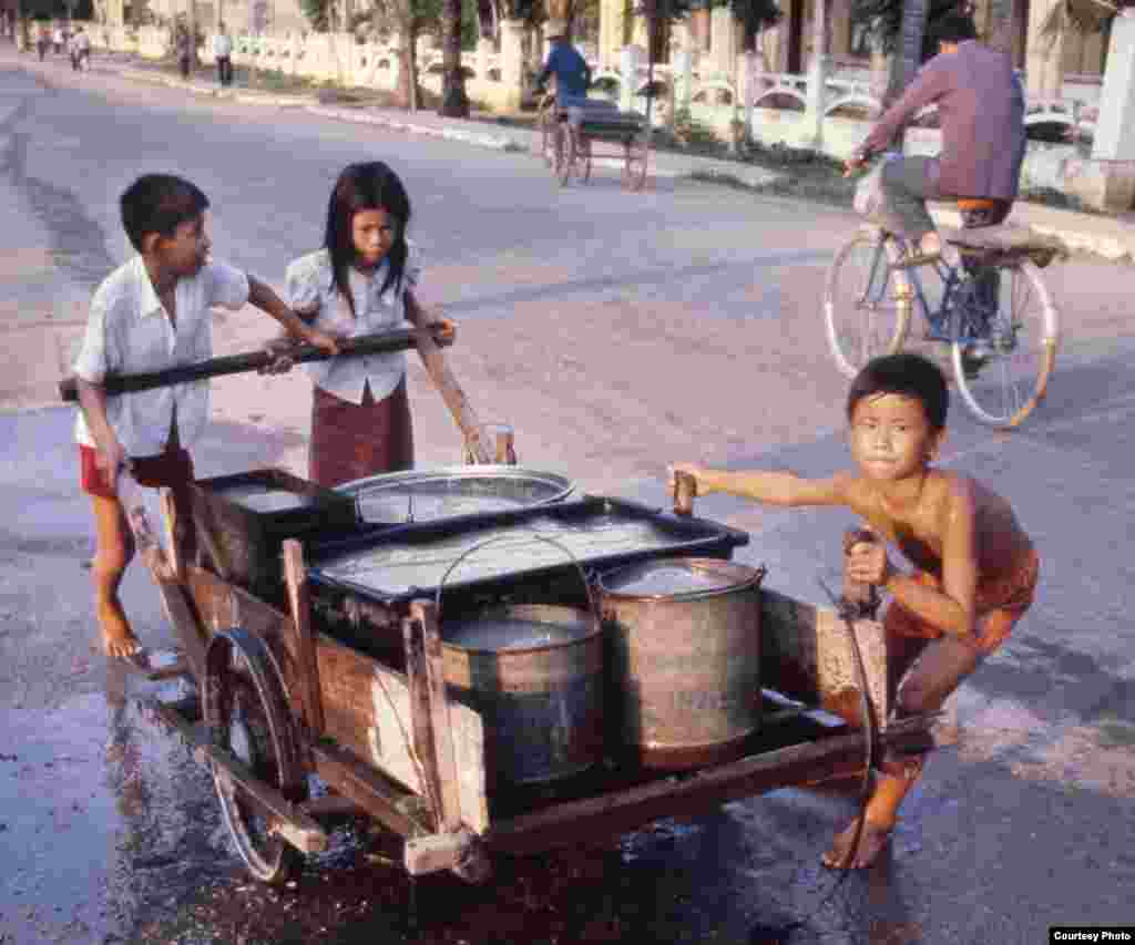 កុមារ​កម្ពុជា​ជញ្ជូន​ទឹក​ដើម្បី​យក​ទៅ​ប្រើប្រាស់​។ ​រូបភាព​ថតនៅភ្នំពេញ​ ​ក្នុង​ឆ្នាំ១៩៨០។ ​(រូប​ផ្តល់​ឱ្យ​ដោយលោក​​ John Burgess)