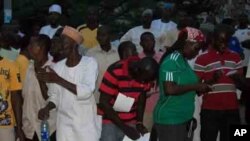 Voters and party agents recording election results at a polling station in Abuja, Nigeria's capital