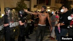 Seorang pria menghadapi polisi di luar kantor Kepolisian Kenosha di Kenosha, Wisconsin, AS, dalam aksi protes menyusul penembakan polisi terhadap pria kulit hitam, Jacob Blake, 23 Agustus 2020. 