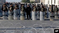Iraqi riot police close a bridge leading to the heavily guarded Green Zone during a demonstration of followers of Iraq's influential Shiite cleric Muqtada al-Sadr in Baghdad, Iraq, Feb. 11, 2017.