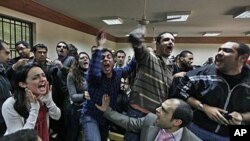 Egyptian protesters chant anti-military ruling slogans during a trial of employees of pro-democracy groups charged with using foreign funds to foment unrest in Cairo, February 26, 2012. 