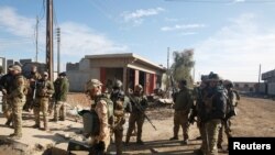 Les forces irakiennes sont sur les lieux de l'attentat à l'est de Mossoul, en Irak, le 22 décembre 2016.