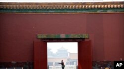 អ្នក​ទេសចរ​ម្នាក់​ដែល​ពាក់​ម៉ាស់​ការពារ​មេរោគ​កូរ៉ូណា​ដើរ​កាត់​វិមាន Forbidden City ក្នុង​ក្រុង​ប៉េកាំង កាលពី​ថ្ងៃទី១ ខែឧសភា ឆ្នាំ២០២០។