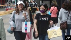 People wear face masks to protect against the spread of the coronavirus as they walk through a shopping district in Taipei, Taiwan, Thursday, Oct. 29, 2020. (AP Photo/Chiang Ying-ying)
