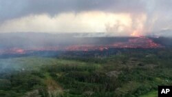 In this aerial photo provided by the U.S. Geological Survey, lava flows from fissure 8 near Pahoa, Hawaii, May 30, 2018. The lava channel was estimated to be about 100 feet wide. Fountain heights continued to reach 230 to 260 feet (70 to 80 meters) above ground level, May 31, 2018.