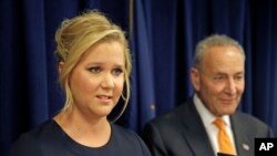 Aktris/komedian Amy Schumer berbicara didampingi sepupunya, Senator Charles Schumer, dalam konferensi pers di New York (3/8). (AP/Seth Wenig)