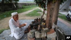 Kashmiri Hindu man, Sham Lal, 63 performs evening prayers at the Muthi migrant camp in Jammu, India, Aug. 29, 2019. Tens of thousands of Kashmiri Hindus fled the restive region nearly 30 years ago.
