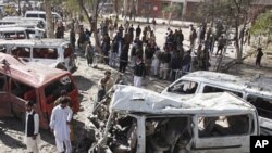 People visit the site of a bomb blast at a bus station in Peshawar, Pakistan, February 23, 2012.