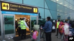 Passengers stand at a distance and wear masks amid the COVID-19 pandemic as they wait in line to check in at the Jorge Chávez International Airport in Callao, Peru, July 15, 2020.