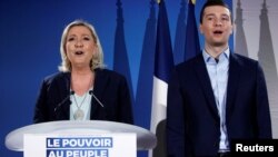 French far-right National Rally (Rassemblement National) party leader Marine Le Pen and Jordan Bardella, the head of the National Rally list for the European elections, sing the national anthem during a meeting in Saint-Paul-du-Bois, France, Feb. 17, 2019