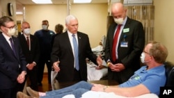 Vice President Mike Pence visits Dennis Nelson, a patient who survived the coronavirus during a tour of the Mayo Clinic Tuesday, April 28, 2020, in Rochester, Minn., and chose not to wear a face mask, an apparent violation of the medical center's policy.