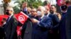 FILE - The leader of Tunisia's Islamist Ennahda party, House Speaker Rached Ghannouchi, waves a Tunisian flag during a rally in Tunis, Tunisia, Feb. 27, 2021. 