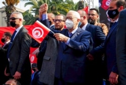 The leader of Tunisia's Islamist Ennahda party, House Speaker Rached Ghannouchi, waves a Tunisian flag during a rally in Tunis, Tunisia, Feb. 27, 2021.