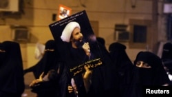 FILE - Protester holds up a picture of Sheikh Nimr al-Nimr during a rally in coastal town of Qatif, Saudi Arabia.