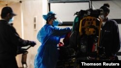 Health care workers treat a patient outside the emergency room at the Community Hospital of Huntington Park during a surge in COVID-19 cases in Huntington Park, Calif., Dec. 29, 2020.