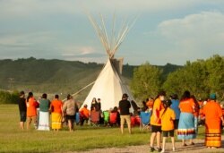 A vigil takes place where ground-penetrating radar recorded hits of what are believed to be 751 unmarked graves near the grounds of the former Marieval Indian Residential School on the Cowessess First Nation, Saskatchewan, June 26, 2021.