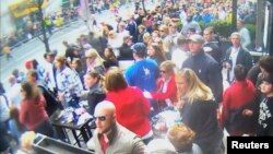 A still image captured from surveillance video at the Boston Marathon shows the scene moments before a second bomb exploded as a man, marked with a circle by prosecutors (top R) and identified by them as defendant Dzhokhar Tsarnaev, moves rapidly away from the spot near the finish line of the race, April 15, 2013, in this handout video provided by the U.S. Attorney's Office in Boston, March 9, 2015.