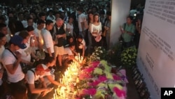Mourners in the Philippine capital, Manila, light candles and lay flowers in front of a memorial outside the Resorts World Manila entertainment complex, June 3, 2017. On Friday, a gunman entered the complex and set fire to its casino, triggering a blaze that left at least 38 people dead. 