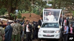 Paus Fransiskus melambaikan tangan kepada warga setempat saat berkendara dengan 'popemobile'-nya menuju gereja Katolik "Santo Joseph The Worker" di wilayah Kangemi, Nairobi, Kenya (27/11).