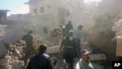 This photo provided by the Syrian Civil Defense White Helmets, which has been authenticated based on its contents and other AP reporting, shows Civil Defense workers and Syrian citizens inspecting damaged buildings after airstrikes hit in Darat Izza town, in rural western Aleppo province, Syria, Saturday, Nov. 5, 2016.