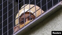 FILE - A migrant looks out the window in the facility for detention of foreigners in Bela-Jezova, Czech Republic, Nov. 5, 2015.