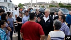 Presiden AS Donald Trump dan Gubernur Puerto Rico Ricardo Rosselló berbicara dengan warga di Guaynabo, Puerto Rico pasca badai Maria dalam kunjungan hari Selasa (3/10). 