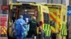 Medics transport a patient from an ambulance to the Royal London Hospital as the spread of the coronavirus disease (COVID-19) continues in London, Britain, Jan. 1, 2021.