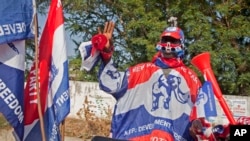 FILE - A supporter of the New Patriotic Party wears campaign paraphernalia on the side of a road in Accra, Ghana, Nov. 23, 2012. The election for Ghana's next president will be held December 7.
