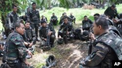 Malaysian soldiers confer during an operation in Sungai Nyamuk, a village adjacent to Kampung Tanduo, Malaysia, March 14, 2013. A contingent of Malasian troops is now heading ro Somalia.