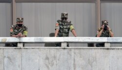 North Korean soldiers keep watch toward the south as South Korean Unification Minister Lee In-young inspects the truce village of Panmunjom, Sep. 24, 2020.