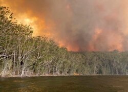 Smoke and wildfire rage behind Lake Conjola, Australia, Jan. 2, 2020.