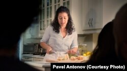 Actress Nadine Malouf chops onions for kubah as she tells the audience about her search for her lover through the war-torn Syrian landscape.