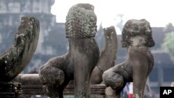 In this photo taken, June 27, 2010, lion statues sit in front of the famed Angkor Wat in Siem Reap province, about 320 kilometers (199 miles) north of Phnom Penh, Cambodia. 