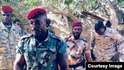 Le lieutenant général John Tshibangu, à l’avant-plan, entouré d’hommes armés en tenues militaires, à côté de véhicules 4x4, scandant des slogans pour un groupe appelé Forces nouvelles du Congo, dans des vidéos postées sur les réseaux sociaux, 18 janvier 2018. 