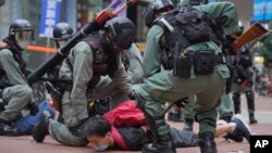 Polisi anti huru-hara menahan seorang demonstran di Causeway Bay, Hong Kong, 24 Mei 2020. (AP Photo/Vincent Yu)