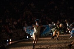 Actors and actresses of State Theatre of North Greece wearing masks perform Aristophanes' Comedy 'The Birds' at the ancient theater of Epidaurus, Aug. 7, 2020.