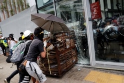 Protesters try to break into the Legislative Council building where riot police are seen, during the anniversary of Hong Kong's handover to China in Hong Kong, July 1, 2019.