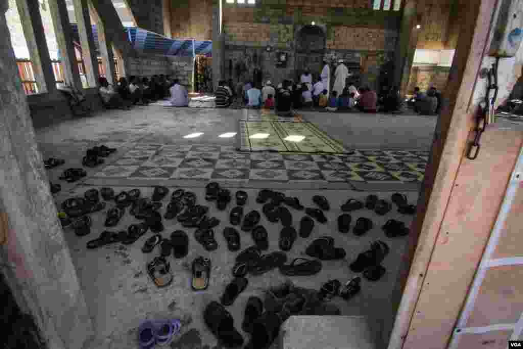 Men from the community, which mainly comes from the same village in Syria, gather to pray. (Photo - J. Owens/VOA)