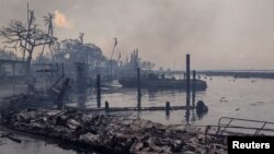 Sebuah perahu hangus tergeletak di tepi laut yang hangus setelah kebakaran hutan yang dipicu oleh angin topan di kejauhan yang menghancurkan kota Lahaina di Maui, Hawaii, AS, 9 Agustus 2023. (Mason Jarvi/Handout via REUTERS)