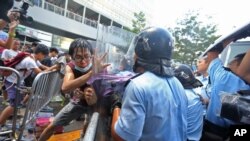 Polisi anti huru hara berupaya menghalau para demostran yang memaksa untuk menuju kantor pemerintah pusat dan berunjuk rasa di Hong Kong, Sabtu pagi (27/9).
