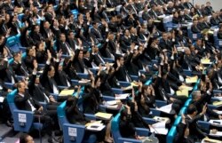 Members of the parliament representing the military-backed Palang Pracharath party raise their hands, approving the nomination of Prayuth Chan-ocha as Thailand's prime minister during a session in Bangkok, Thailand, June 5, 2019.
