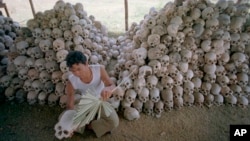 FILE - A man cleans a skull near a mass grave at the Chaung Ek torture camp run by the Khmer Rouge in this undated photo. The last surviving leaders of the Khmer Rouge regime were convicted of genocide, crimes against humanity and war crimes Nov. 16 by an international tribunal.