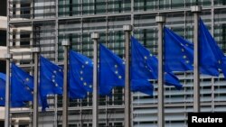 FILE - European Union flags are seen outside the European Commission headquarters in Brussels, Sept. 10, 2014. 