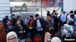 Des Palestiniens ayant la double nationalité se rassemblent devant le poste frontière de Rafah avec l'Égypte.