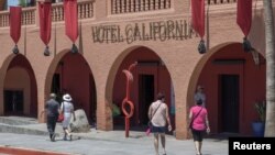 FILE - Tourists walk along the streets of the town of Todos Santos, Baja California Sur, Mexico, May 2, 2017. 