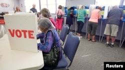 FILE - Voters fill in their ballots at a crowded polling station on North Carolina's first day of early voting for the general elections, in Carrboro, N.C., Oct. 20, 2016. 
