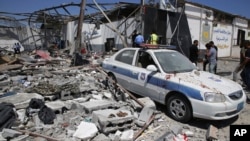 Debris covers the ground and an emergency vehicle after an airstrike at a detention center in Tajoura, east of Tripoli in Libya, Wednesday, July 3, 2019. 