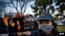 지난 2021년 3월 미국 조지아주 애틀랜타 연쇄총격 사건 다음 날 캘리포니아주에서 열린 희생자 추모 집회 참가자가 아시아계 혐오 중단을 요구하는 구호를 들어보이고 있다. (자료사진) 