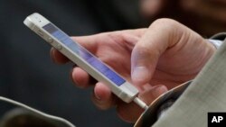 FILE - A man uses a smartphone in an Aug. 11, 2014, illustration photo.